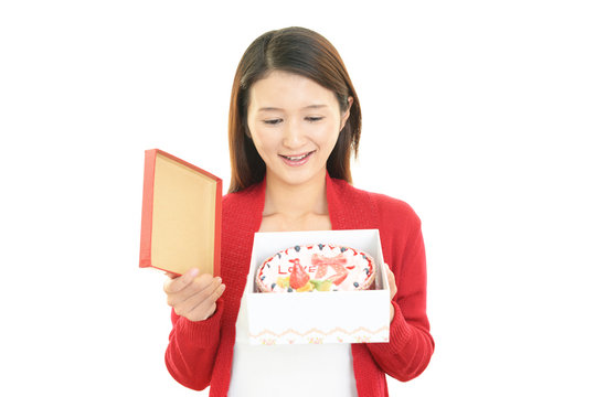 ケーキを持つ笑顔の女性