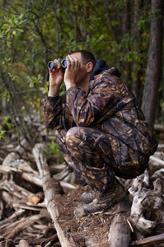 man with binoculars out hunting