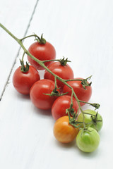 Fresh cherry tomatoes on a white wooden table. Selective focus