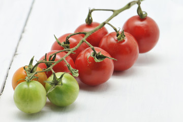 Fresh cherry tomatoes on a white wooden table. Selective focus