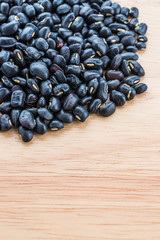 Black beans on wooden background