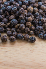 Black pepper on wood background