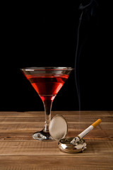 cigarette in an ash-tray and glass of wine