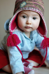 A little girl in a warm funny cap