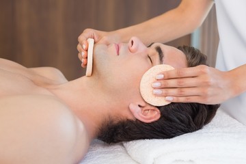 Obraz na płótnie Canvas Man receiving facial massage at spa center