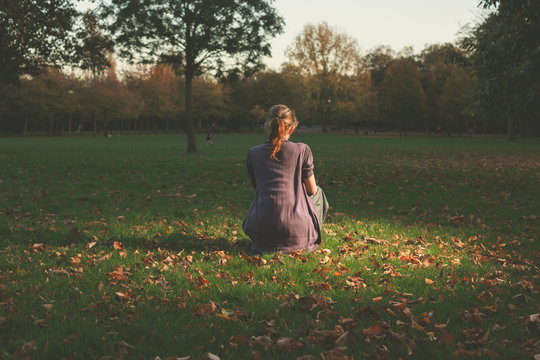 Woman sitting on the grass in evening