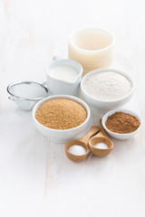 Ingredients for baking muffins on a white wooden background