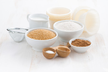 Ingredients for baking muffins on a white wooden background