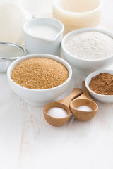 Ingredients for baking muffins on white table, close-up