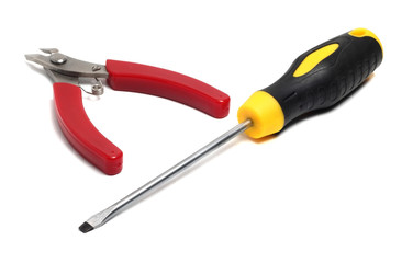 small pliers and a flat screwdriver long on a white background