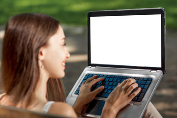 Young woman with laptop in the park