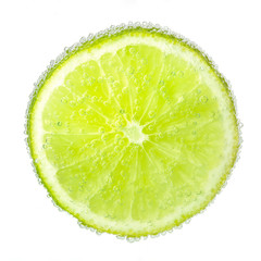 Nice ripe and juicy slice of a lime covered with bubbles.