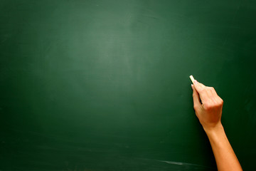Female hand draw something on blackboard