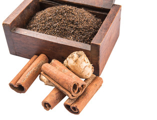 Processed tea leaves in wooden box with ginger and cinnamon