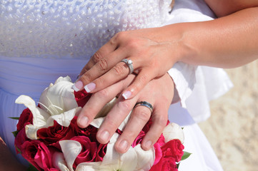 Wedding couple hands on red flowers