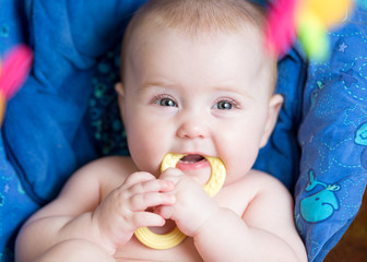 laying baby girl using teether