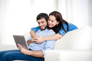 couple on couch using digital tablet computer online internet