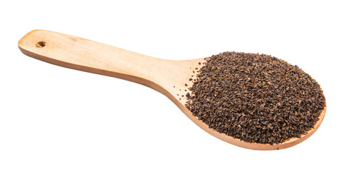 Dried, processed tea leaves in wooden spoon over white 