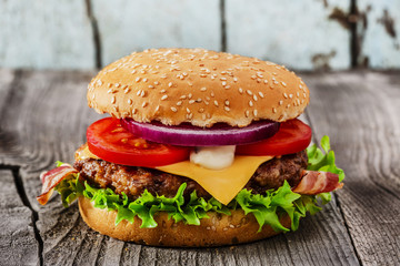 hamburger with grilled meat  cheese  bacon on a wooden surface