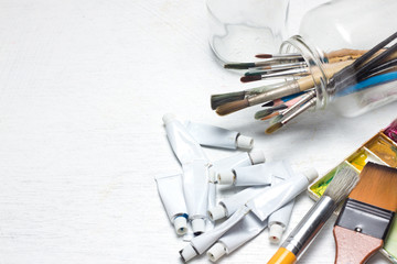 Fototapeta premium Various dirty paint brushes in a jar with shallow depth of field