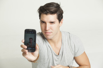 young attractive man taking pictures of him self with phone