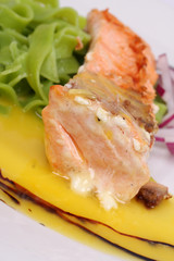 Grilled salmon with green pasta and onions with orange sauce