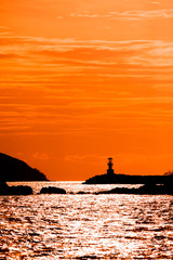 Beautiful seascape with silhouette lighthouse on sunset