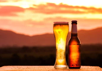Poster Bottle and Glass of light beer on sunset © arhendrix
