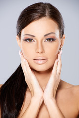 Obraz premium Stunning brunette with her hands to cheeks