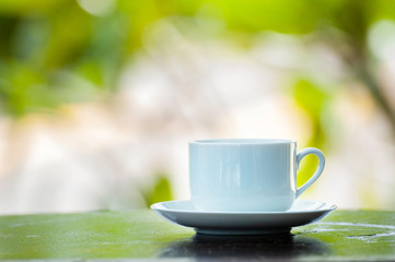 coffee cup on wood over nature background