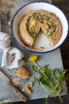 dandelion and chicory savory pie on plate on wooden table