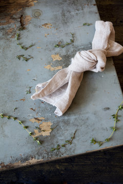 knotted towel on rustic blue scraped wooden table with thyme