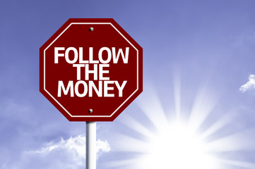 Follow the Money written on red road sign