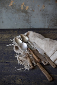 old used kitchen knives on frayed cloth on rustic wooden table