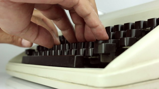 A man typing on a manual typewriter