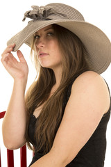 woman black dress red chair hat look serious