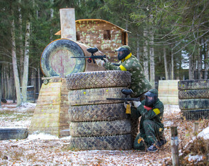 Two friends in paintball club with a model of steam locomotive