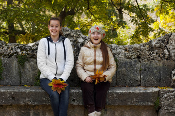 Two girl friends in autumn park