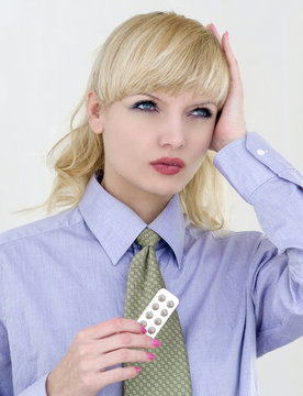 Young beautiful business woman with migraine and pills
