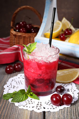 Fresh cold cherry cocktail with mint, ice and lemon