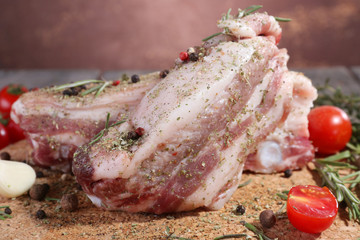raw bacon with spices and tomatoes on wooden table
