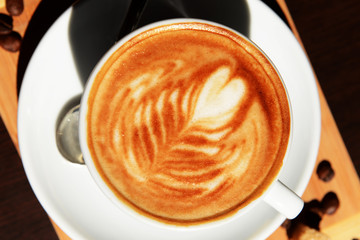 Cup of coffee with cute drawing in cafe