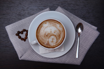 Cup of coffee with cute drawing in cafe
