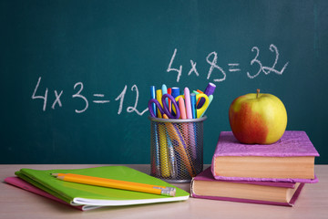 School supplies on table on board background