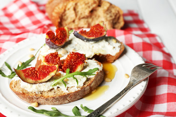 Tasty sandwiches with sweet figs and cottage cheese on plate
