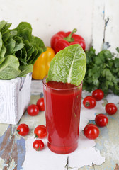 Glass of tomato juice, sorrel in box and fresh vegetables
