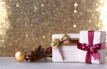 Fototapeta na wymiar Gift box and Christmas decor on table on shiny background