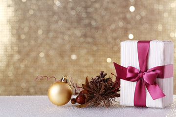 Fototapeta na wymiar Gift box and Christmas decor on table on shiny background