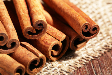 Cinnamon sticks on sackcloth on table close up
