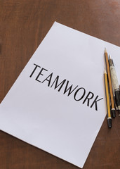 BLANK PAPER WITH WORD TEAMWORK ON IT.
